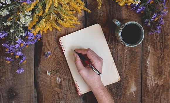 journaling on table with cup of coffee